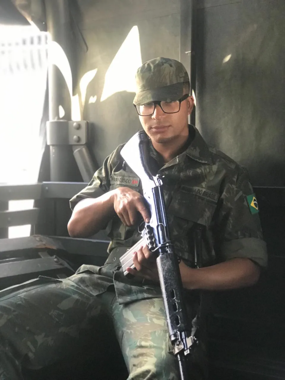 Daniel P Francisco de uniforme camuflado e boné, sentado no interior de um veículo durante uma missão de campo